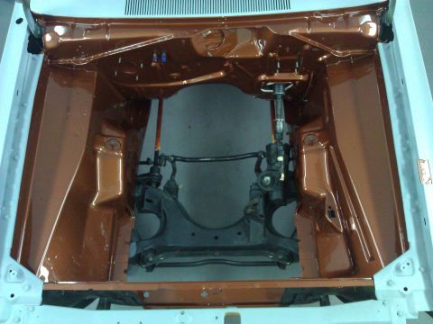 1971 Dodge Dart - The engine bay of a vehicle is shown with copper-colored paint and visible steering and suspension parts.