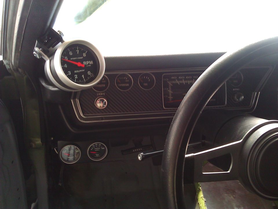 Dashboard of a 1971 Dodge Dart with a tachometer, speedometer, and other gauges visible
