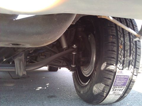 1971 Dodge Dart - Close-up of a vehicle's undercarriage, focusing on the suspension components and a tire with a new tire label.