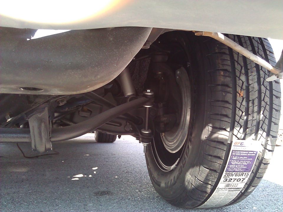Underside view of a car's suspension and a tire with a BFGoodrich 205/65R15 32707 label