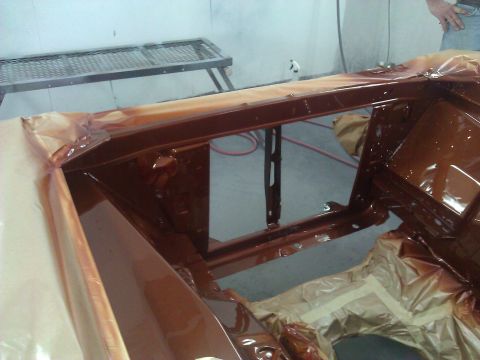 1971 Dodge Dart - The vehicle's frame is being painted in a spray booth, with protective coverings in place.
