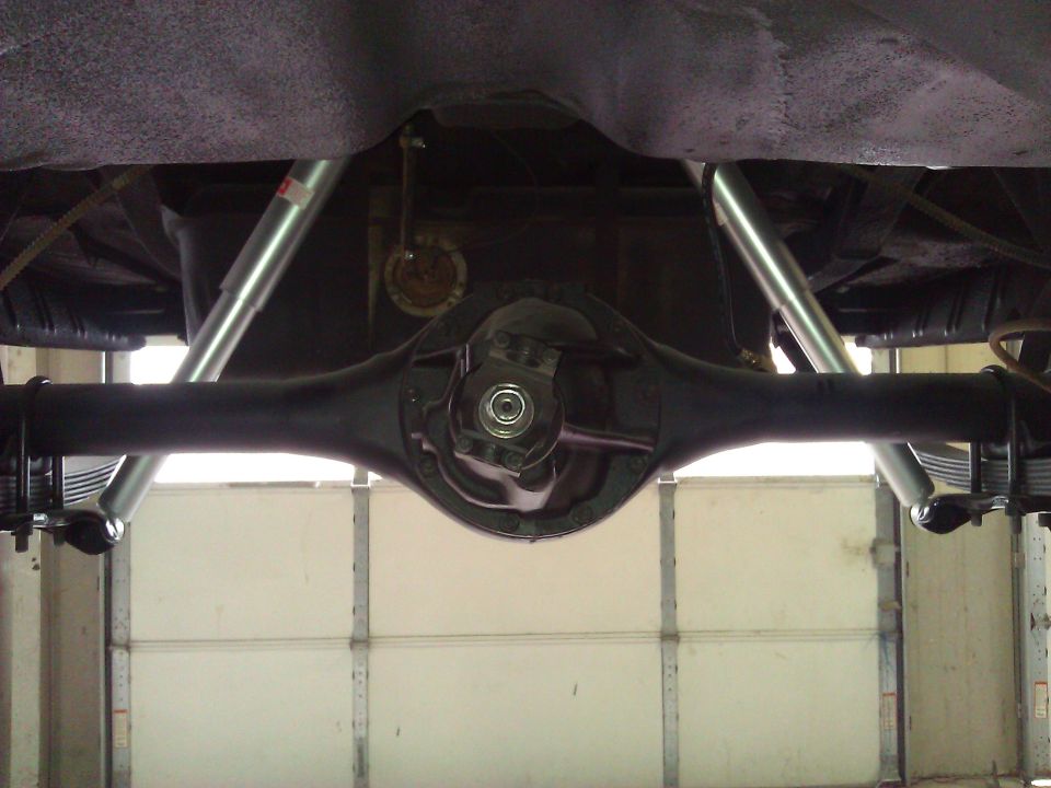 Underside view of a rear axle assembly with leaf springs and shock absorbers