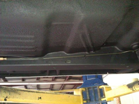 1971 Dodge Dart - The undercarriage of a vehicle is shown from below while it is raised on a hydraulic lift.