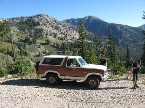 1981 Ford Bronco - A 1981 Ford Bronco is parked on a dirt road with a mountain range visible behind it.