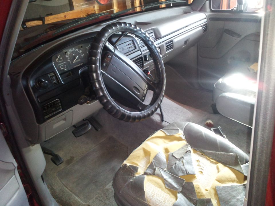 Interior of a 1996 Ford Bronco showing dashboard, steering wheel, and torn driver's seat