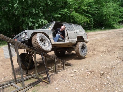 1992 Jeep Cherokee - A heavily modified 1992 Jeep Cherokee navigates an off-road obstacle course, with its driver seated in the open door.