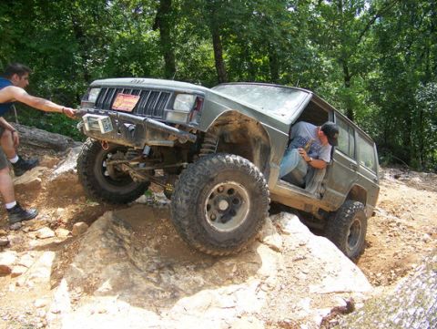 1992 Jeep Cherokee - A modified 1992 Jeep Cherokee tackles a challenging off-road obstacle with assistance from a spotter.