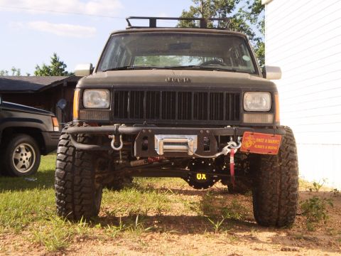 1992 Jeep Cherokee - Modified 1992 Jeep Cherokee, front view, with winch and custom bumper. Another Jeep is parked nearby.