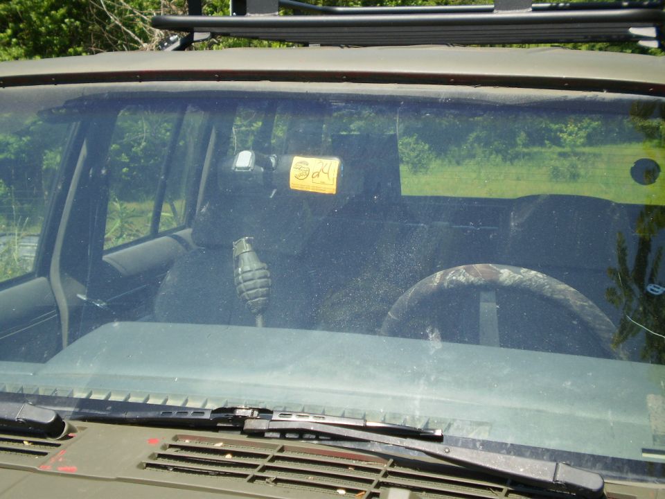 1992 Jeep Cherokee interior showing dashboard with grenade and yellow "Say" sticker on windshield