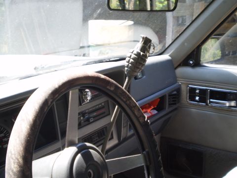 1992 Jeep Cherokee - The interior of a Jeep shows a grenade as a shift knob, with a worn steering wheel and dashboard details.