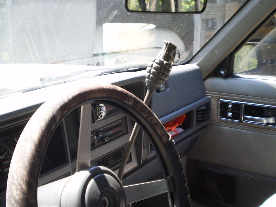 Interior shot of a Jeep with a grenade shift knob and worn steering wheel