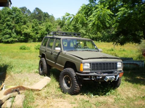 1992 Jeep Cherokee - This modified 1992 Jeep Cherokee features off-road tires, a roof rack, and a front-mounted winch.