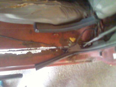 1988 Ford F-150 - Close-up view of rusted metal and trim, likely from a vehicle's undercarriage or door frame.