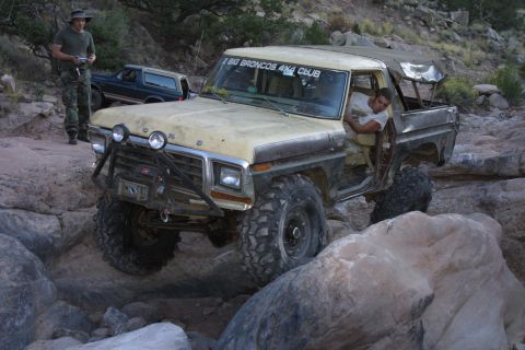 1979 Ford Bronco - A yellow 1978 Ford Bronco navigates a rocky trail, with another Bronco visible in the background.