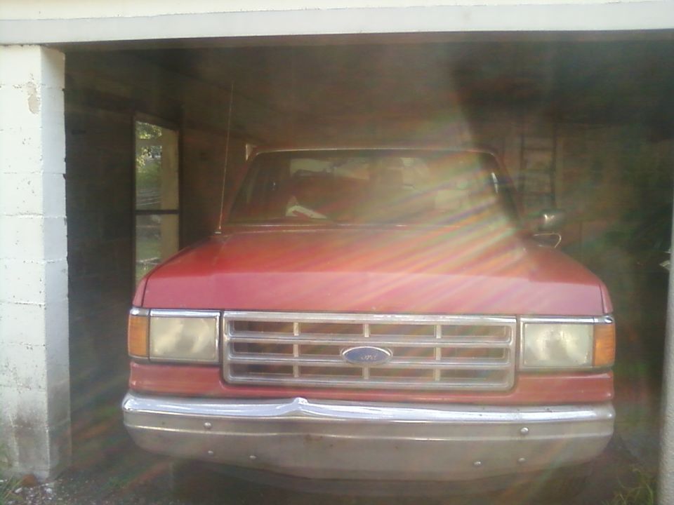 Red 1988 Ford F-150 front view in garage