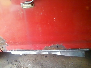 1988 Ford F-150 - Lower door panel shows significant rust damage and a metal patch repair.