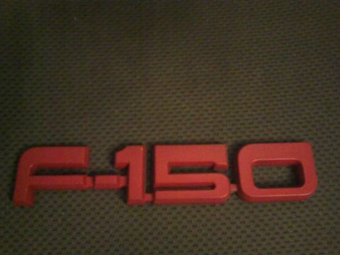 1988 Ford F-150 - A red F-150 emblem is shown against a dark, textured background.