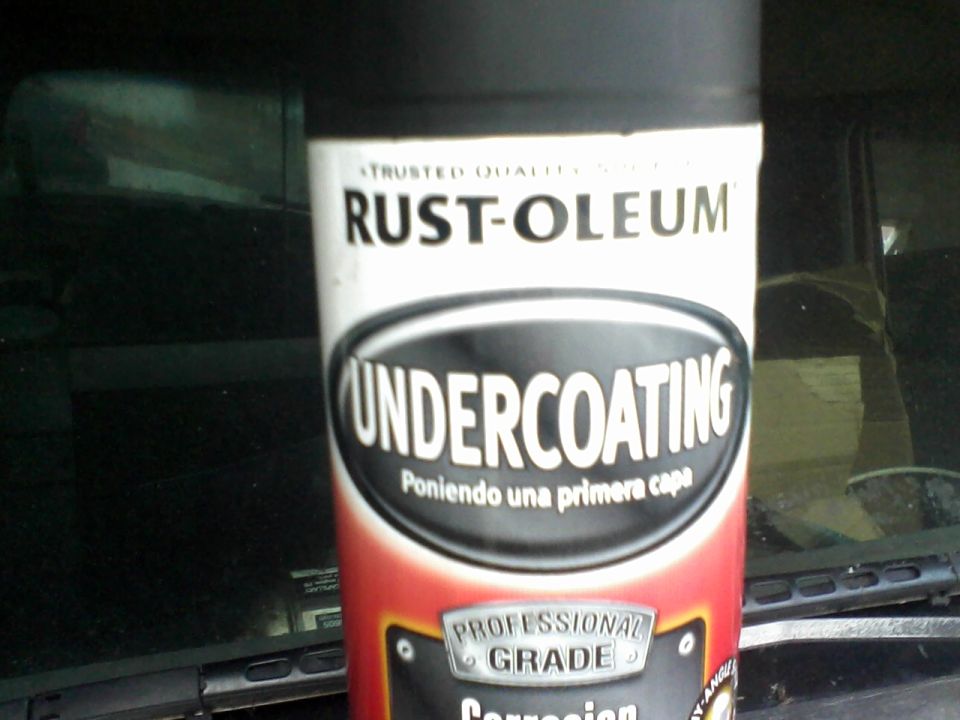 Spray can of Rust-Oleum Undercoating in front of a dark vehicle interior