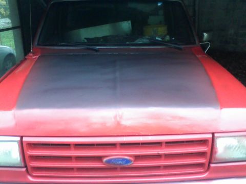 1988 Ford F-150 - Front view of a red Ford truck, likely from the late 1980s, showing its grille and headlights.