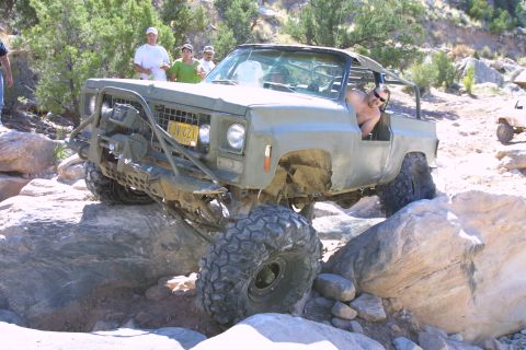 1979 Ford Bronco - This heavily modified off-road vehicle navigates a rocky trail, its extreme suspension and tire capabilities.