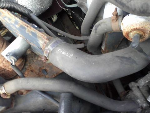 1988 Ford F-150 - Engine bay hoses and clamps are visible, with some signs of rust on the metal components.