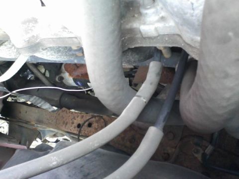 1988 Ford F-150 - Close-up view of hoses and frame components in a vehicle's engine bay.