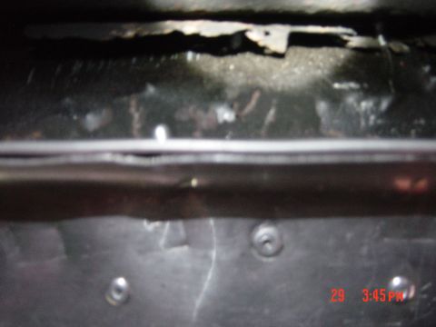 1988 Ford F-150 - Close-up view of the undercarriage of a vehicle, revealing metal parts and signs of wear.