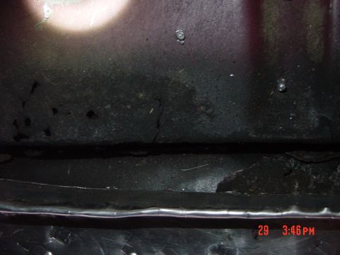 1988 Ford F-150 - A close-up view of dark, textured metal, possibly part of a vehicle's undercarriage, with visible rust and a timestamp overlay.