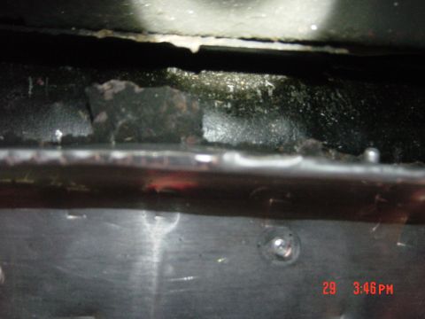 1988 Ford F-150 - A close-up view of the undercarriage of a vehicle, showing signs of wear and tear.