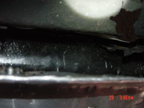 1988 Ford F-150 - Close-up of the underside of a vehicle frame, showing metal components and some wear.