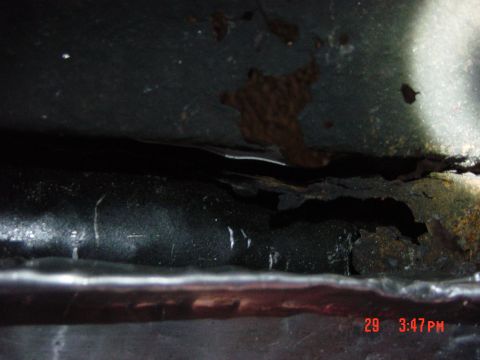 1988 Ford F-150 - The frame of the vehicle shows significant rust and deterioration in this close-up view.