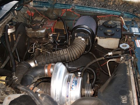 1996 Ford Bronco - The engine bay features a prominent supercharger and aftermarket air intake system.