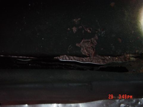 1988 Ford F-150 - Close-up of rust damage on a vehicle's lower body panel, obscuring any specific year or model identification.