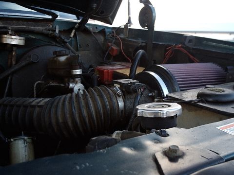 1996 Ford Bronco - Close-up view of a vehicle's engine bay, showing various components and an aftermarket air filter.