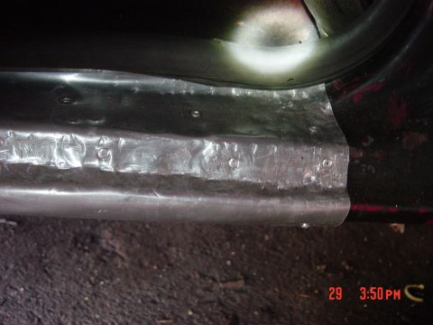 1988 Ford F-150 - Metal repair work on the door sill of a vehicle, with visible rivets and hammered metal sections.