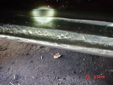 1988 Ford F-150 - A close-up view of a damaged metal panel, showing numerous dents and imperfections.