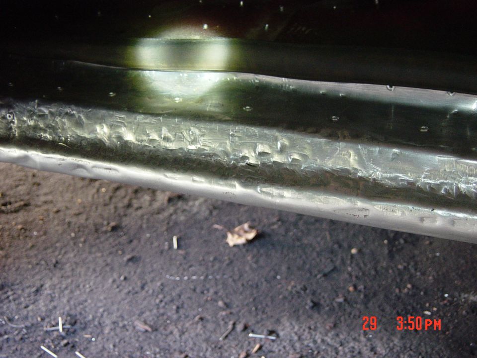 Dented metal panel with rivets, close-up view. Supermotors.net watermark visible