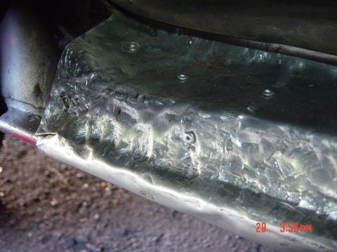 1988 Ford F-150 - Close-up of a repaired metal panel on a vehicle, with visible welding and rivets.