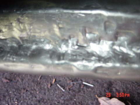 1988 Ford F-150 - Undercarriage detail showing metalwork and debris on the ground.