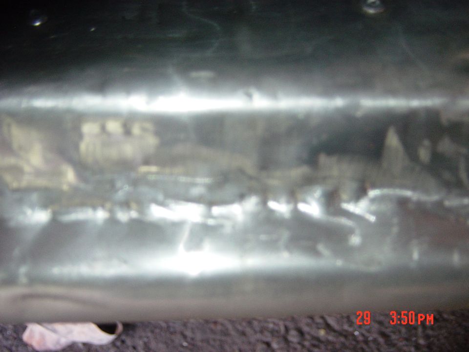 Close-up of a damaged metal panel with reflections and a timestamp overlay