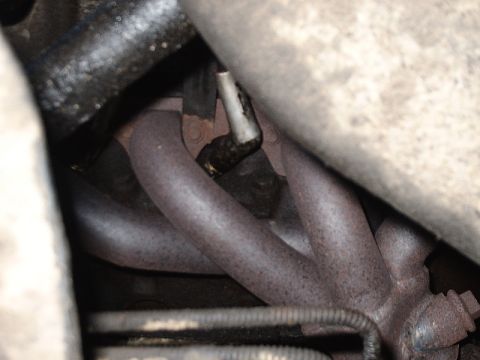1996 Ford Bronco - Engine exhaust manifold with visible rust and a sensor connection.