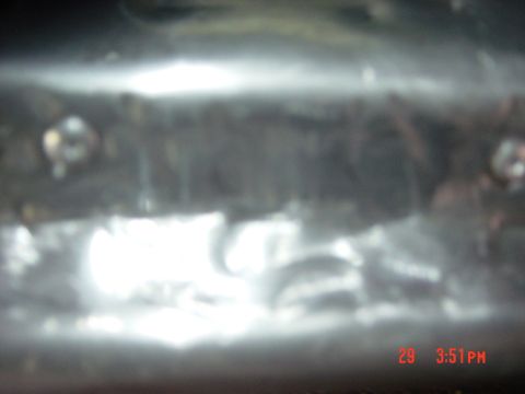 1988 Ford F-150 - A close-up shot of a metallic surface with visible screws and bright reflections, likely an interior detail.