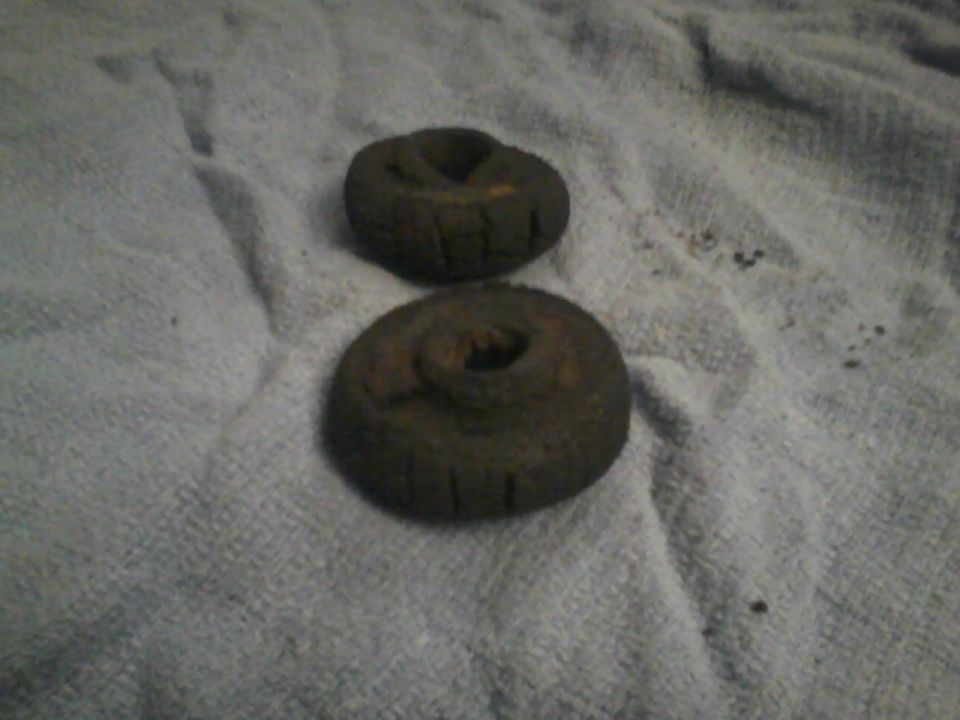 Two dark, circular rubber bump stops on a textured cloth