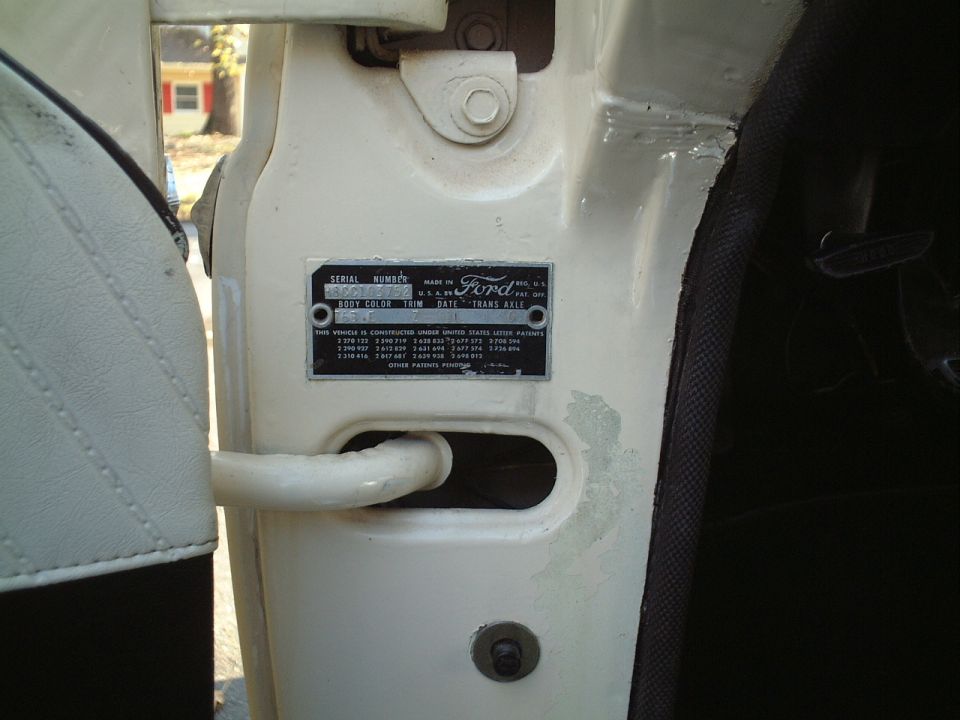 Ford door-jamb serial number and body data tag on a white vehicle