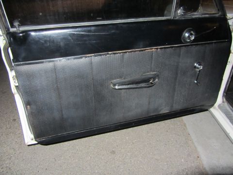 1964 Ford Ranchero - Interior view of a car door panel with a chrome handle and window crank visible.