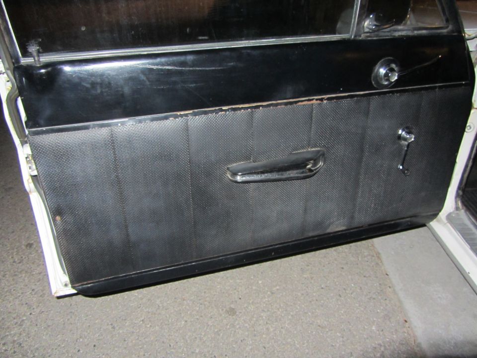 Black textured door panel with chrome handle and window crank