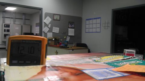 1989 Ford Bronco - A digital thermometer sits on a desk cluttered with office supplies and a calendar on the wall.
