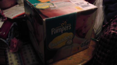 1989 Ford Bronco - A box of Pampers Swaddlers diapers is visible on a table with other items.