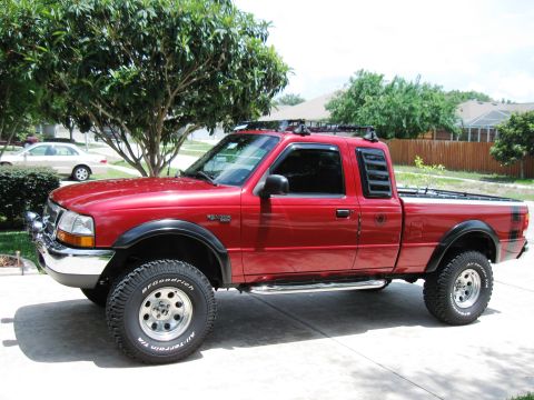 1999 Ford Ranger - Side view of a red 1999 Ford Ranger pickup truck parked in a driveway.