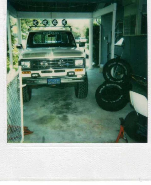 1999 Ford Ranger - A gold Ford Ranger pickup truck is parked in a garage, equipped with KC lights and a custom license plate.